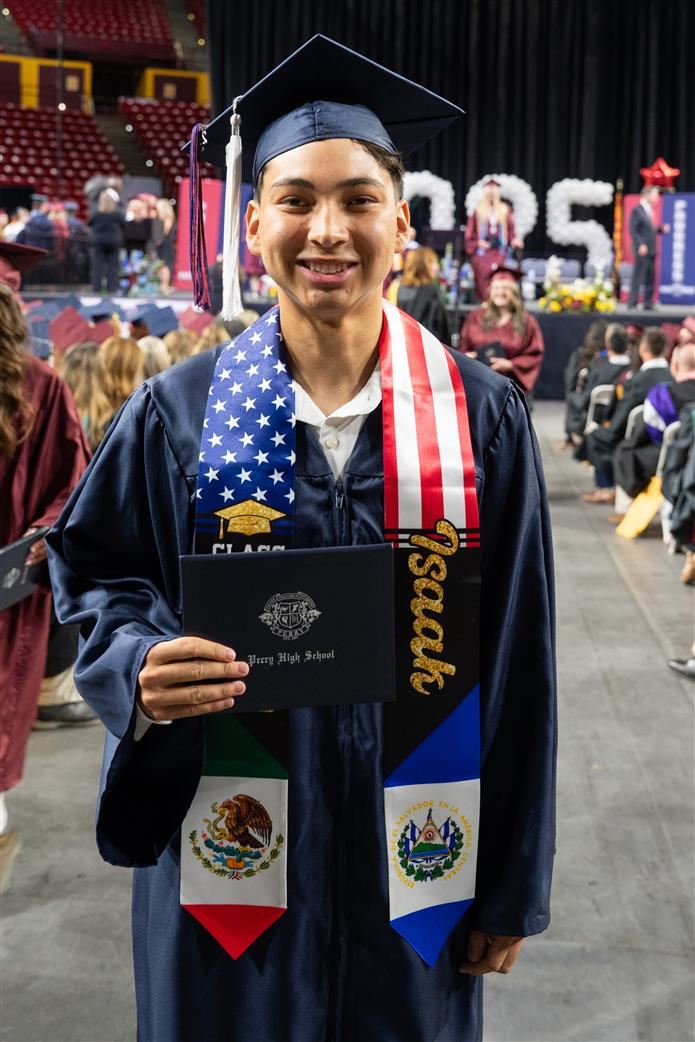Perry High boy (graduate) holding diploma, dressed in cap, gown, stole